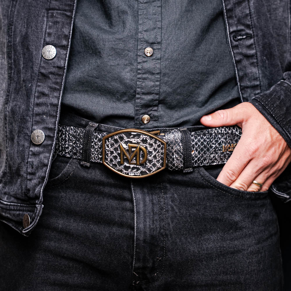 Man wearing Arkansas Belt Antique Newspaper with python skin and antique brass buckle in Western style.