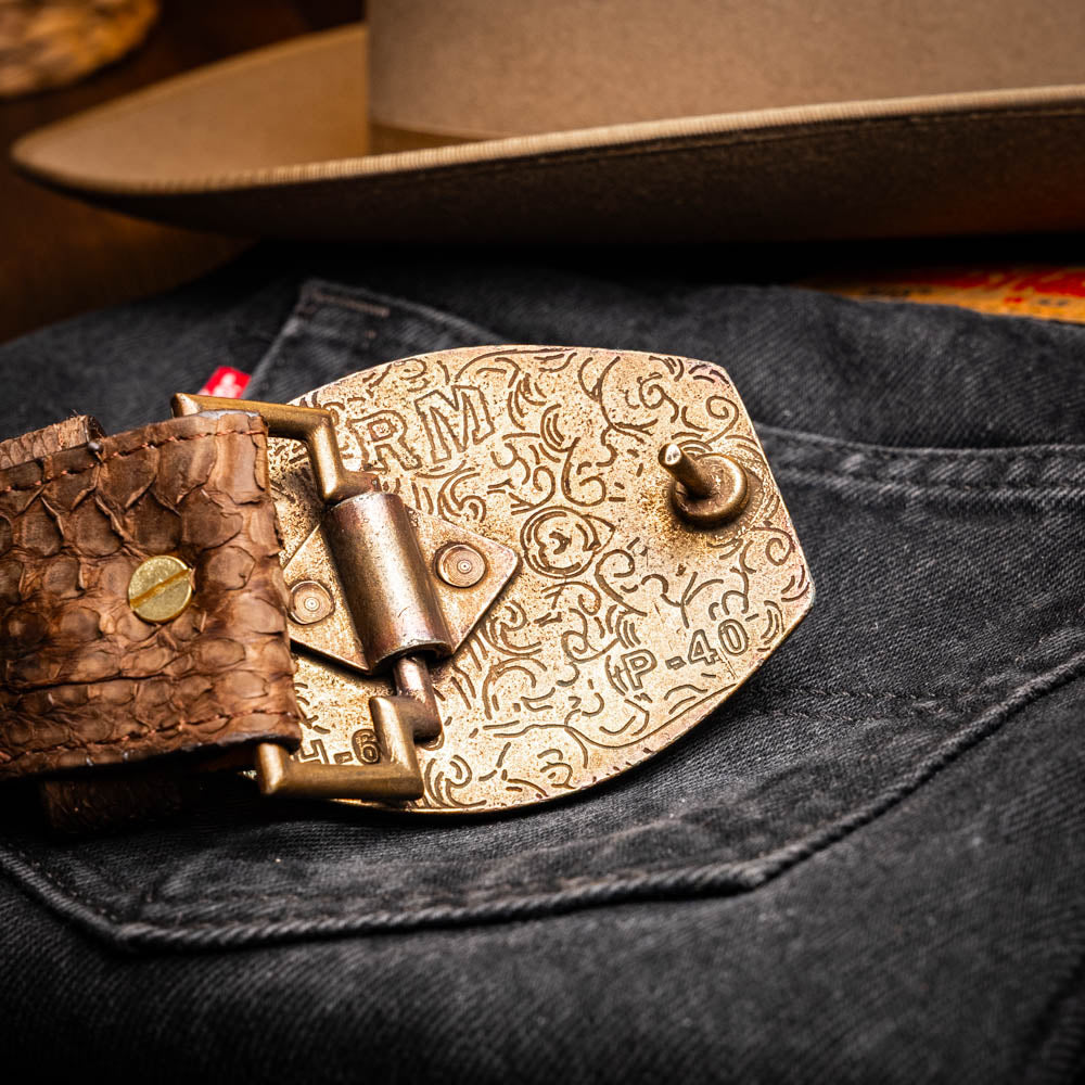 Arkansas Belt Brown with antique brass buckle on denim, showcasing genuine python skin texture and Western style design.