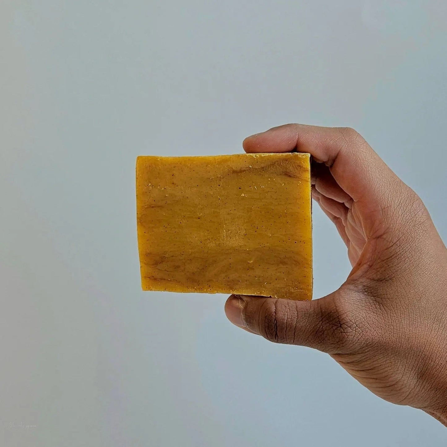 Person holding a bar of Bay Rum Mens Soap – Classic Scent, Modern Clean, showcasing its rich color and crafted texture.