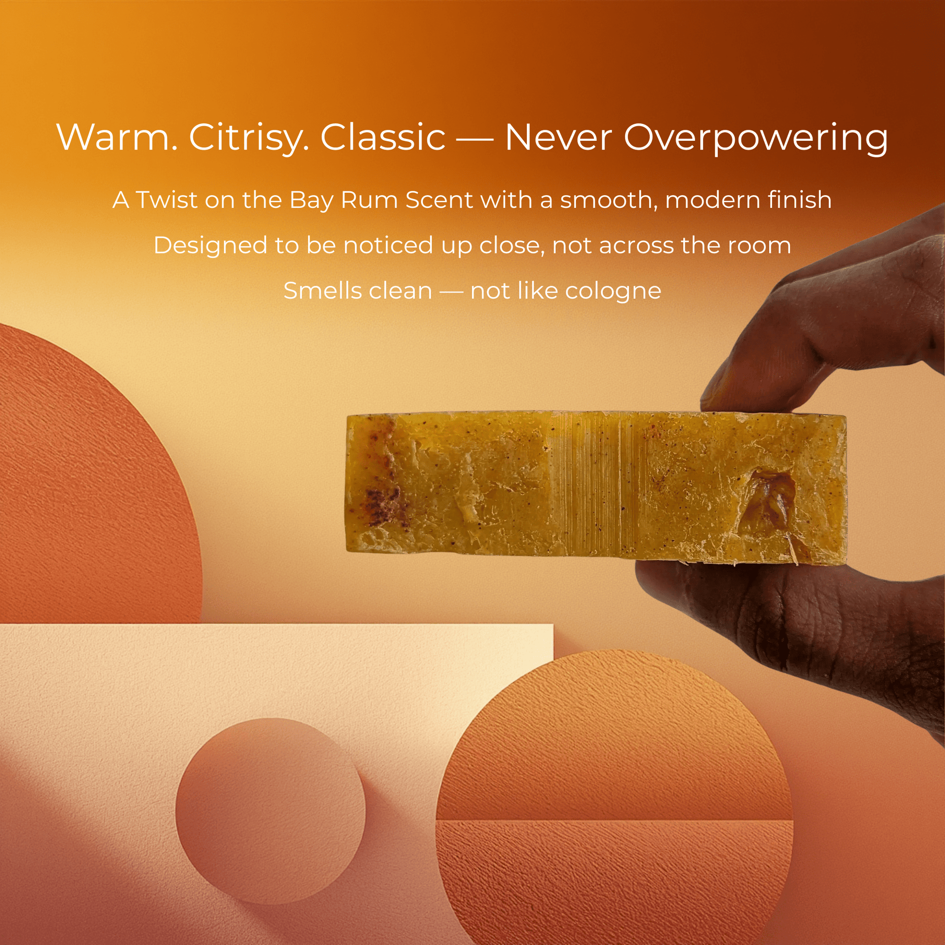 Hand holding Bay Rum Mens Soap against warm background, highlighting its classic scent and modern clean properties.