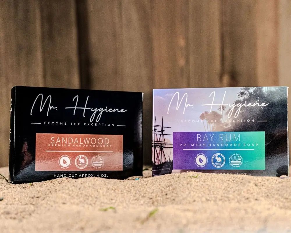 Bay Rum & Sandalwood Bar Soaps on sandy surface, showcasing premium handmade packaging.