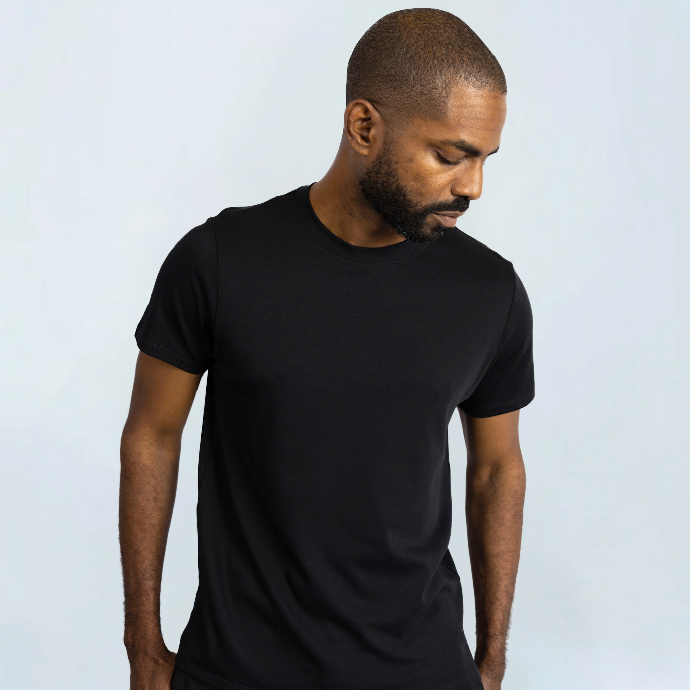 Man wearing a black Short Sleeve Perfect Tee made from Peruvian Pima cotton, showcasing its comfortable and wrinkle-resistant design.