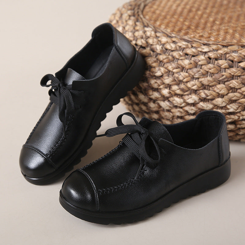 Women’s Black Flat Work Shoes – Soft Sole Anti-Slip Flats on beige background with woven mat in the background.