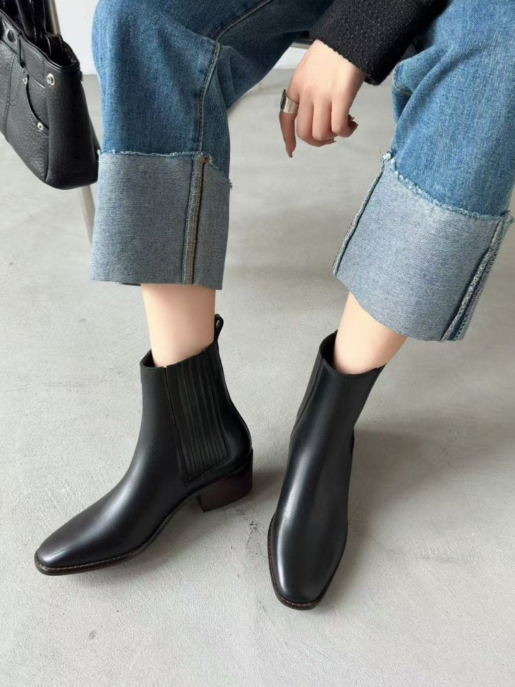 Model wearing Women’s Retro Square-Toe Mid-Heel Chunky Leather Boots with cuffed jeans, showcasing matte leather and chunky heel.