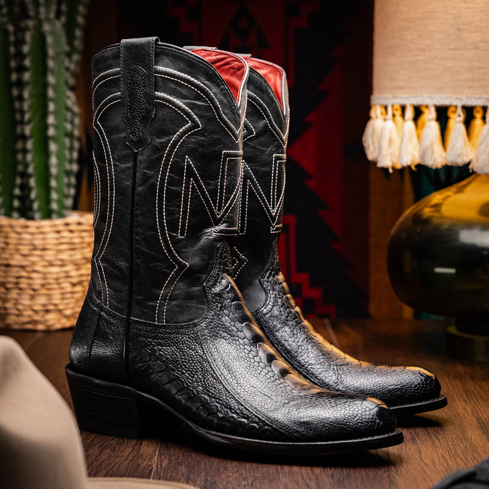 Denver Black Genuine Ostrich Leg Cowboy Boots on display in a Western-themed setting.