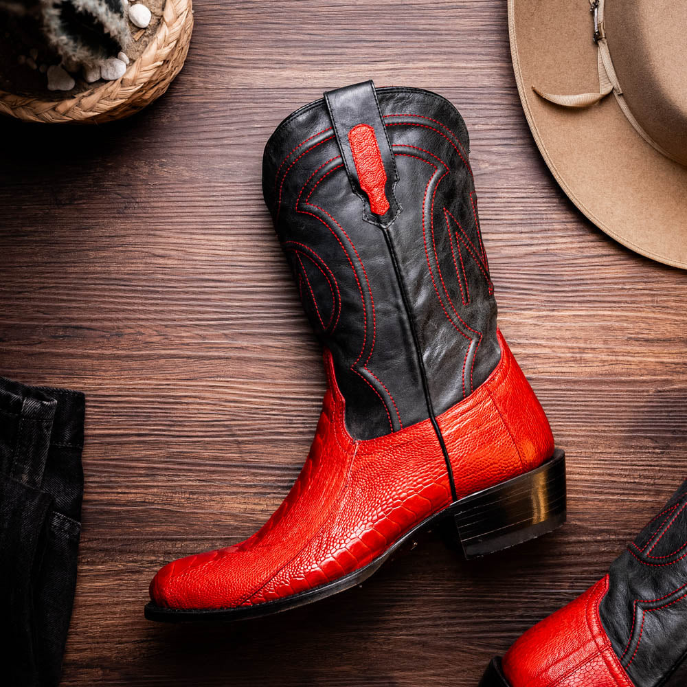 Denver Red ostrich leg cowboy boot with red vamp and black upper on a wooden floor.