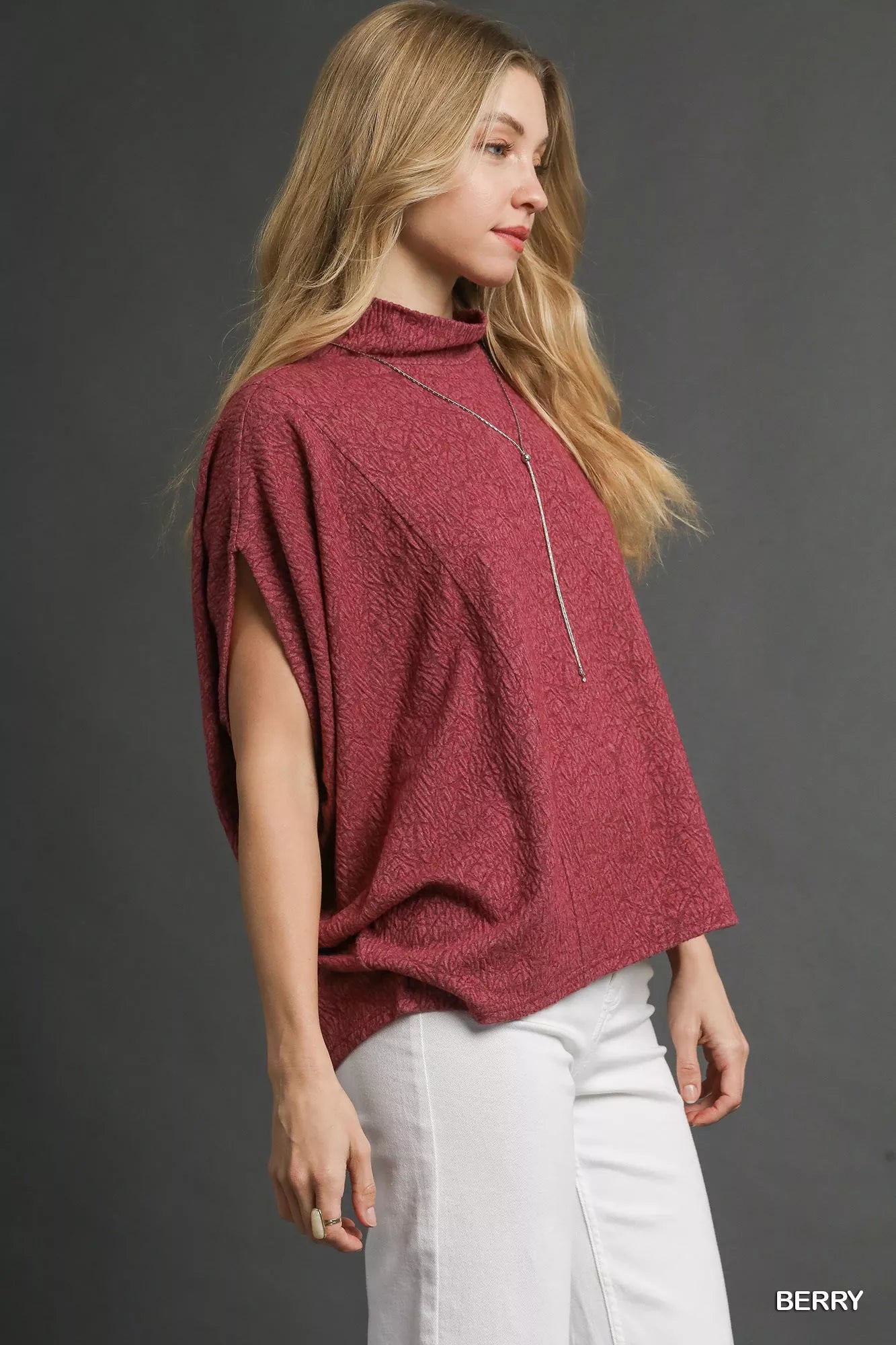 Woman wearing Umgee Textured Mock Neck Relaxed Top in red with white pants
