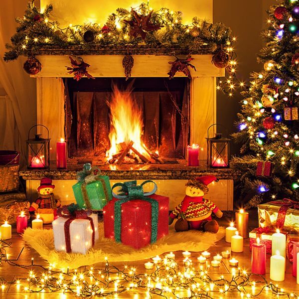 Festive living room with LED60 Light Warm White Christmas Gift Box set near a fireplace, decorated with lights and holiday ornaments.