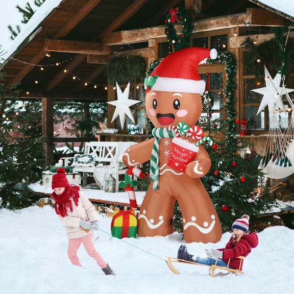 Christmas Inflatable Decoration - 7.9ft gingerbread man with LED lights in snowy yard with children playing