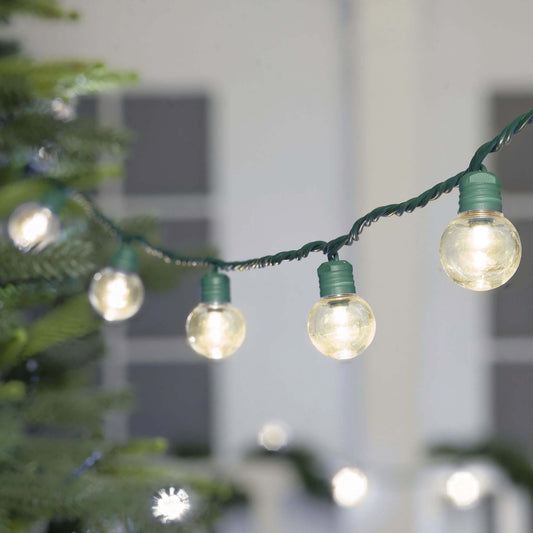 100 Count LED Super Bright G30 Christmas Lights illuminating a tree indoors