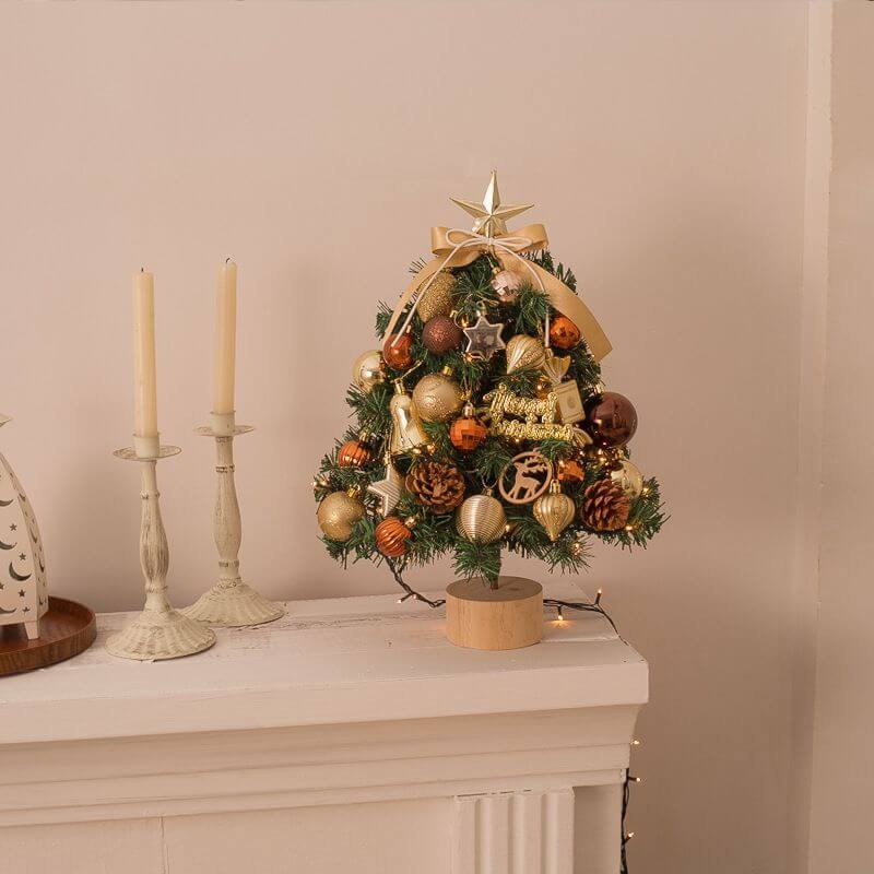 Festive Tabletop Christmas Tree with gold ornaments, snow flocked, perfect for home or office decor.