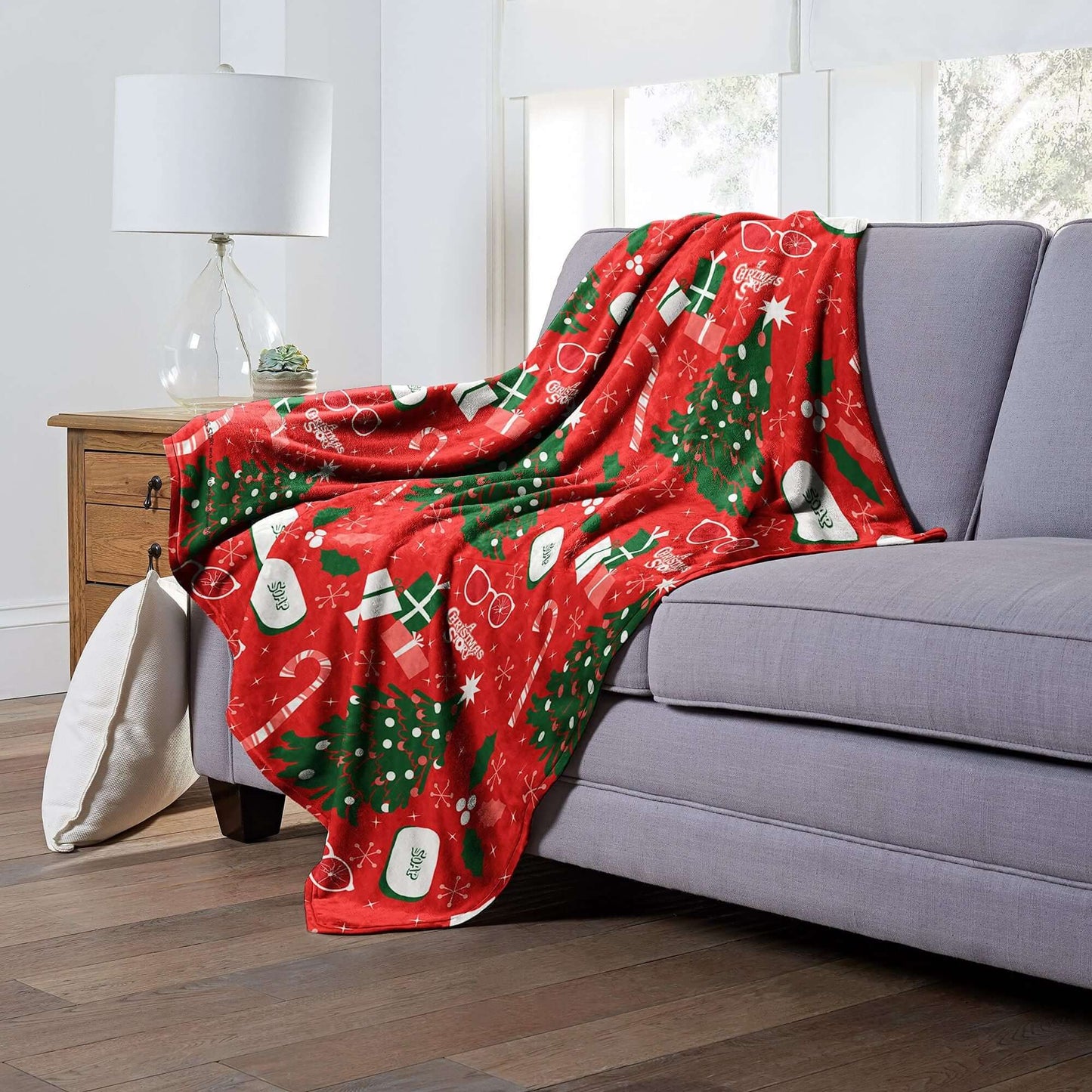 A Christmas Story Silk Touch Throw Blanket on sofa with holiday designs, 50x60 inches, adds festive comfort to living room decor