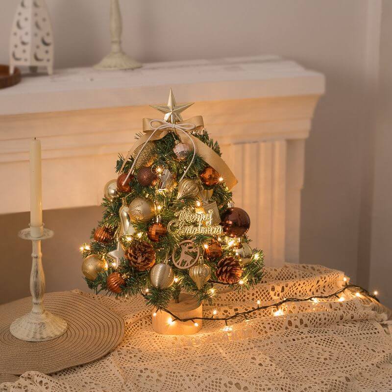 Tabletop Christmas Tree with gold ornaments and snow flocking on a table, ideal for home or office holiday decor.