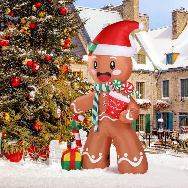 Christmas Inflatable Decoration - 7.9ft Gingerbread Man with LED lights in snowy yard next to decorated Christmas tree.