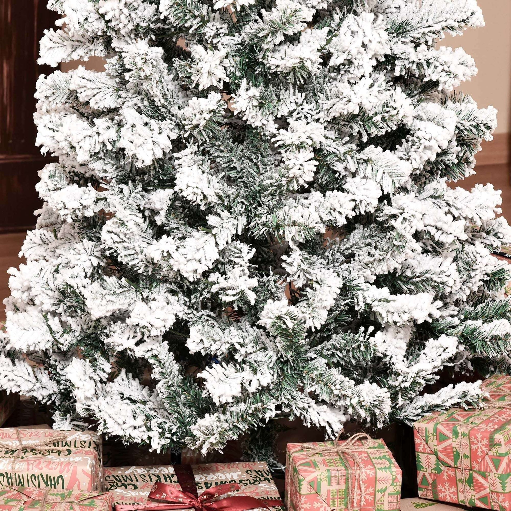 Pre-Lit Snow-Flocked Slim Douglas Fir Tree 7.5ft with gifts beneath, showcasing realistic snow-dusted branches indoors.
