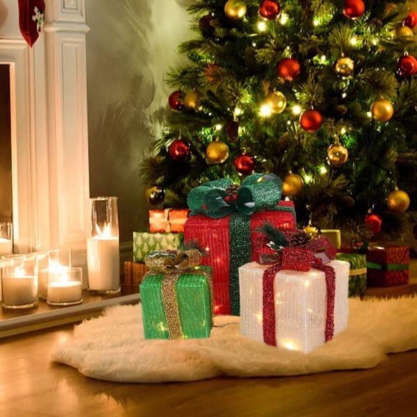 LED60 Light Warm White Christmas Gift Box set under a decorated Christmas tree with candles and festive ornaments.