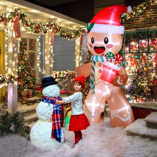 Christmas Inflatable Decoration - 7.9ft gingerbread man with LED lights beside child and snowman in festive outdoor scene