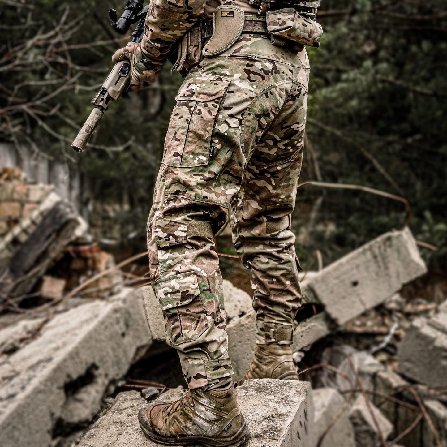 Man wearing VOTAGOO G3 Combat Pants with Knee Pads in Multicam, designed for tactical military and airsoft versatility, standing on rubble.
