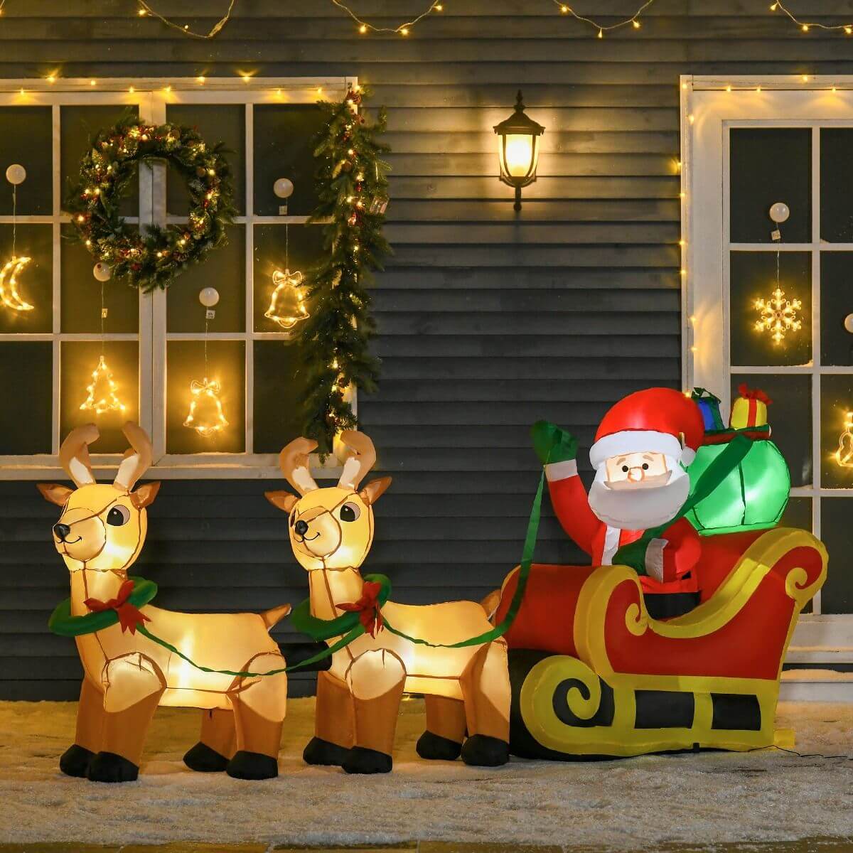 Christmas Inflatable Santa Claus with Sleigh - 8ft LED outdoor decoration with reindeer, glowing in a festive yard display.