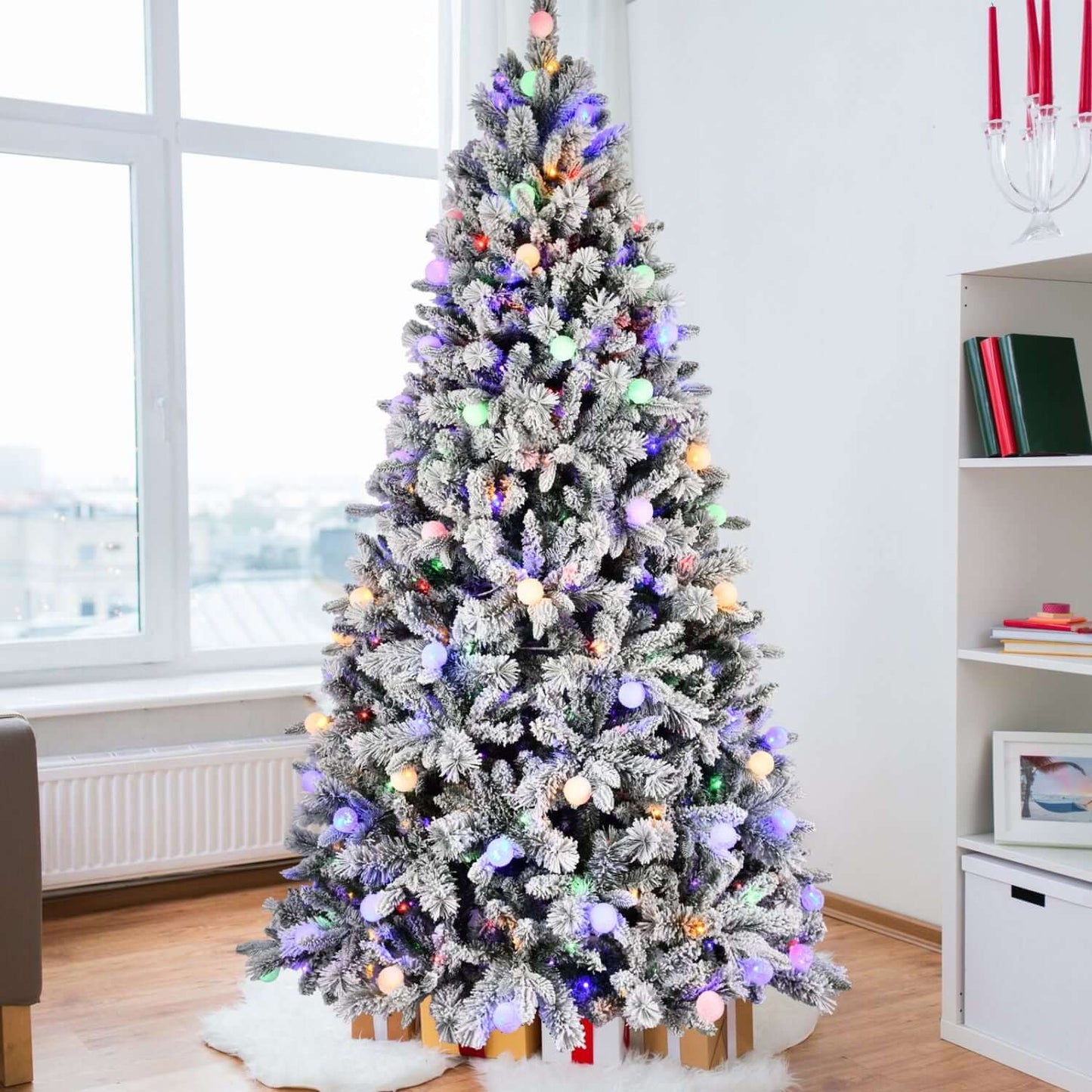 Flocked Christmas Tree with Colorful Lights - 8ft with 10 modes, snow-flocked branches for winter charm in a cozy modern living room.