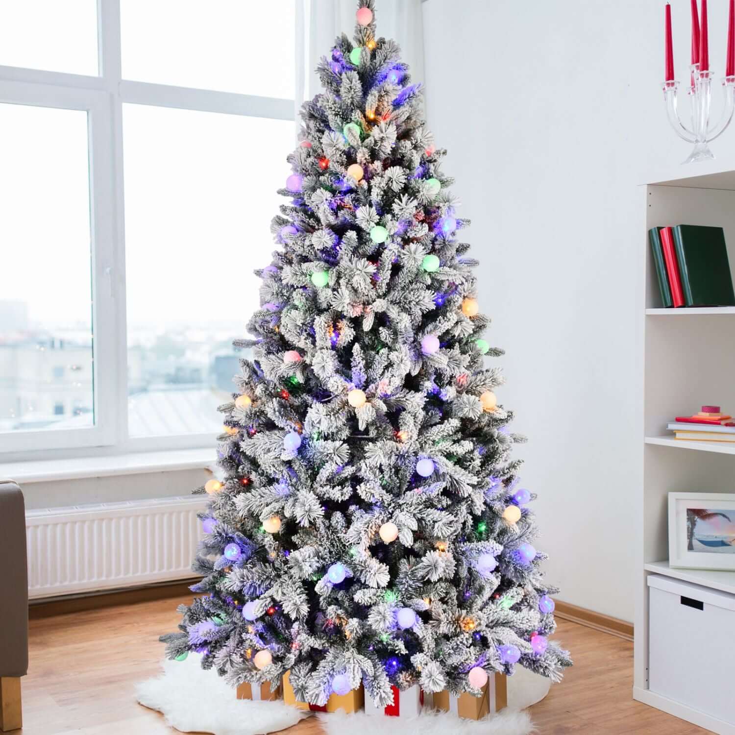 Flocked Christmas Tree with Colorful Lights - 8ft with 10 modes, snow-flocked branches for winter charm in a cozy modern living room.
