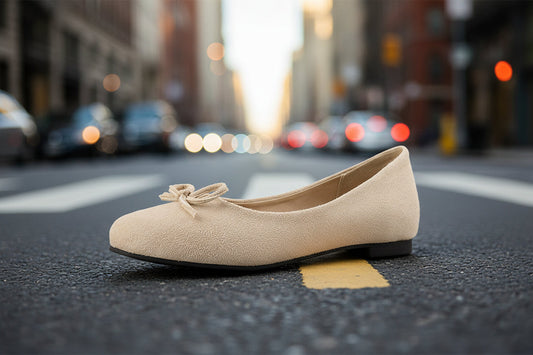 Beige flat shoe with bow on city street, background of blurred urban traffic lights