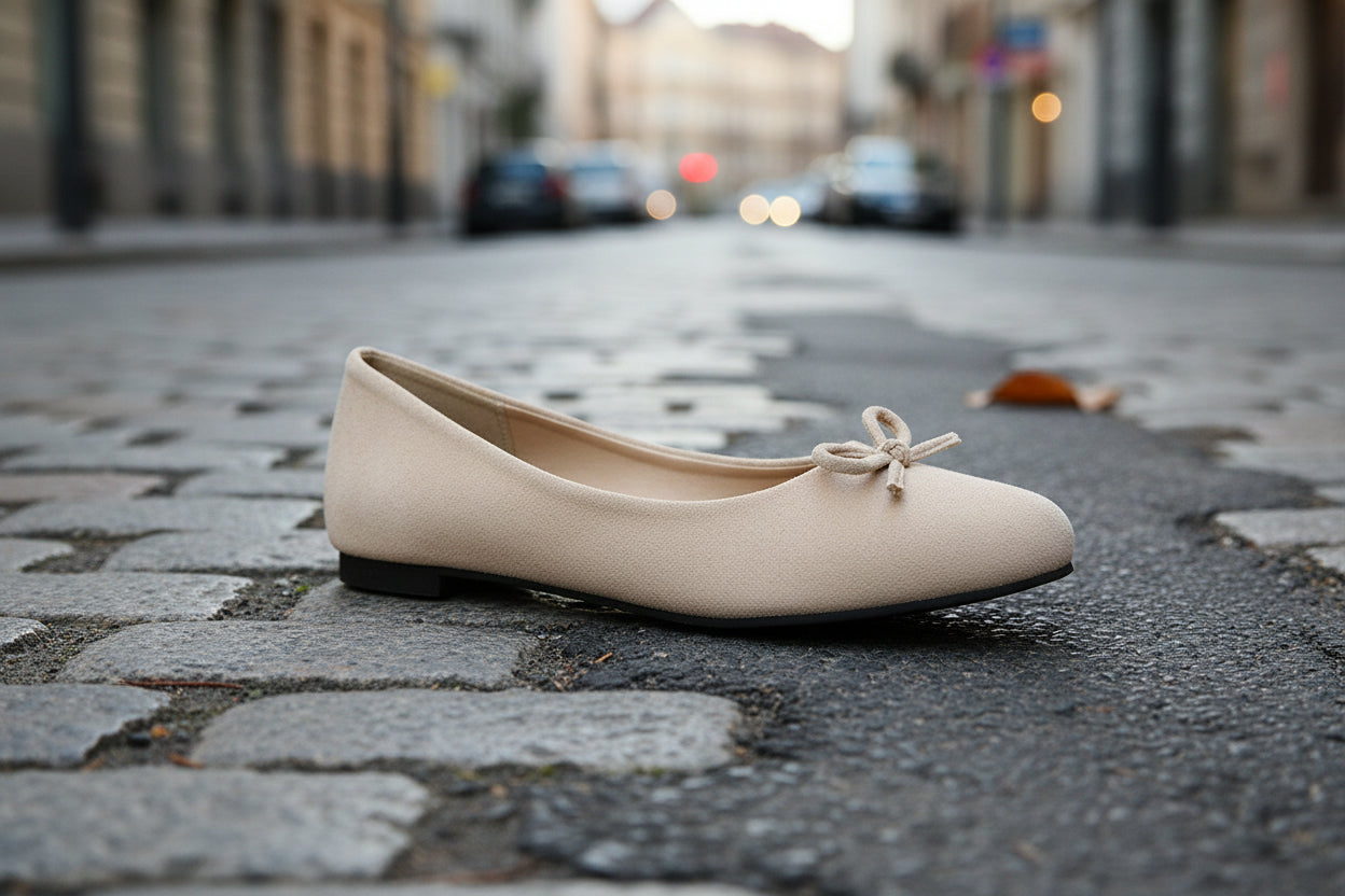 Beige women's flat shoe on cobblestone street