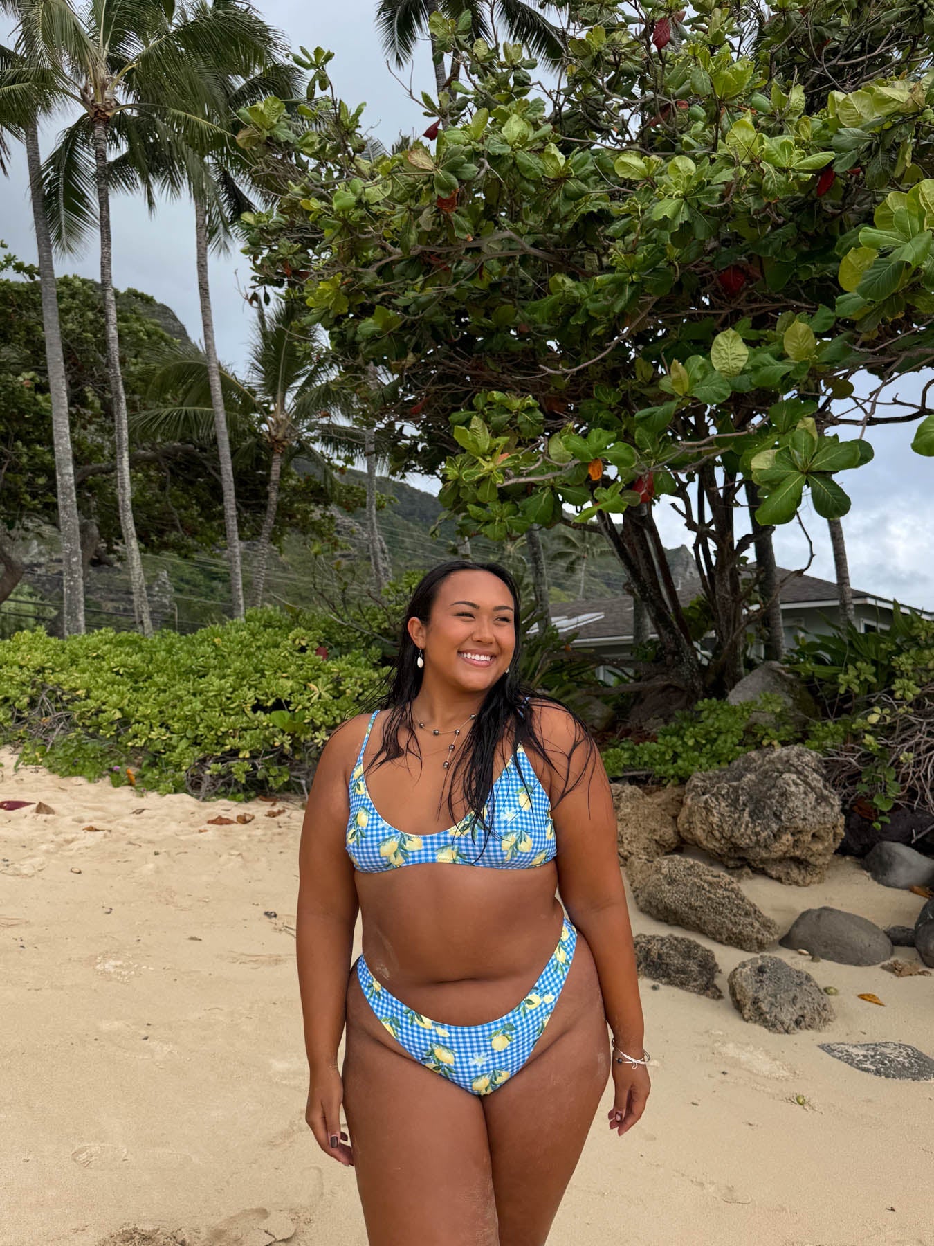 Woman wearing blue floral bikini on tropical beach with palm trees