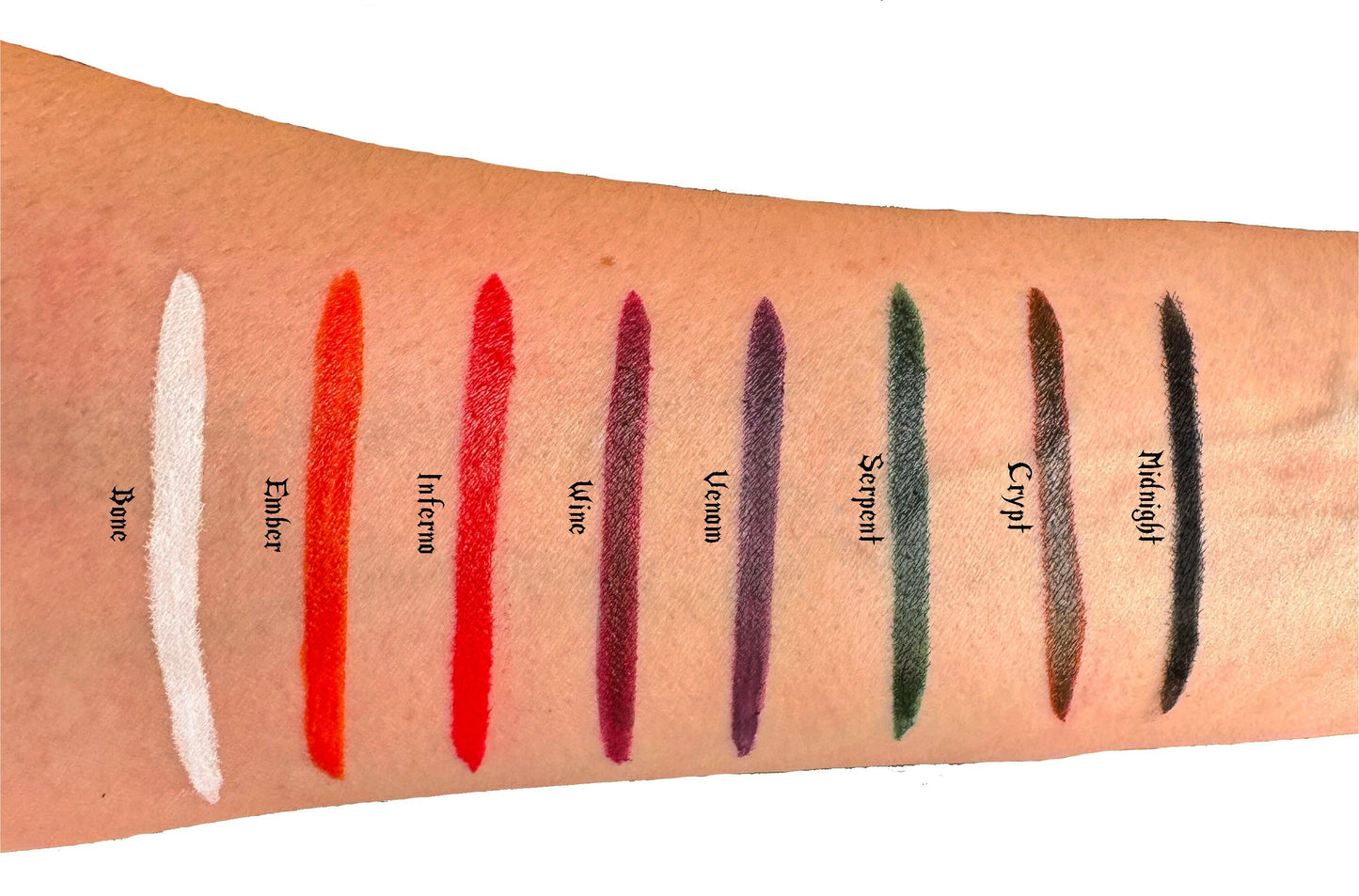 Inferno liquid eyeliner swatch on arm with other vibrant colors, including Ember, Wine, Venom, Serpent, Crypt, and Midnight.