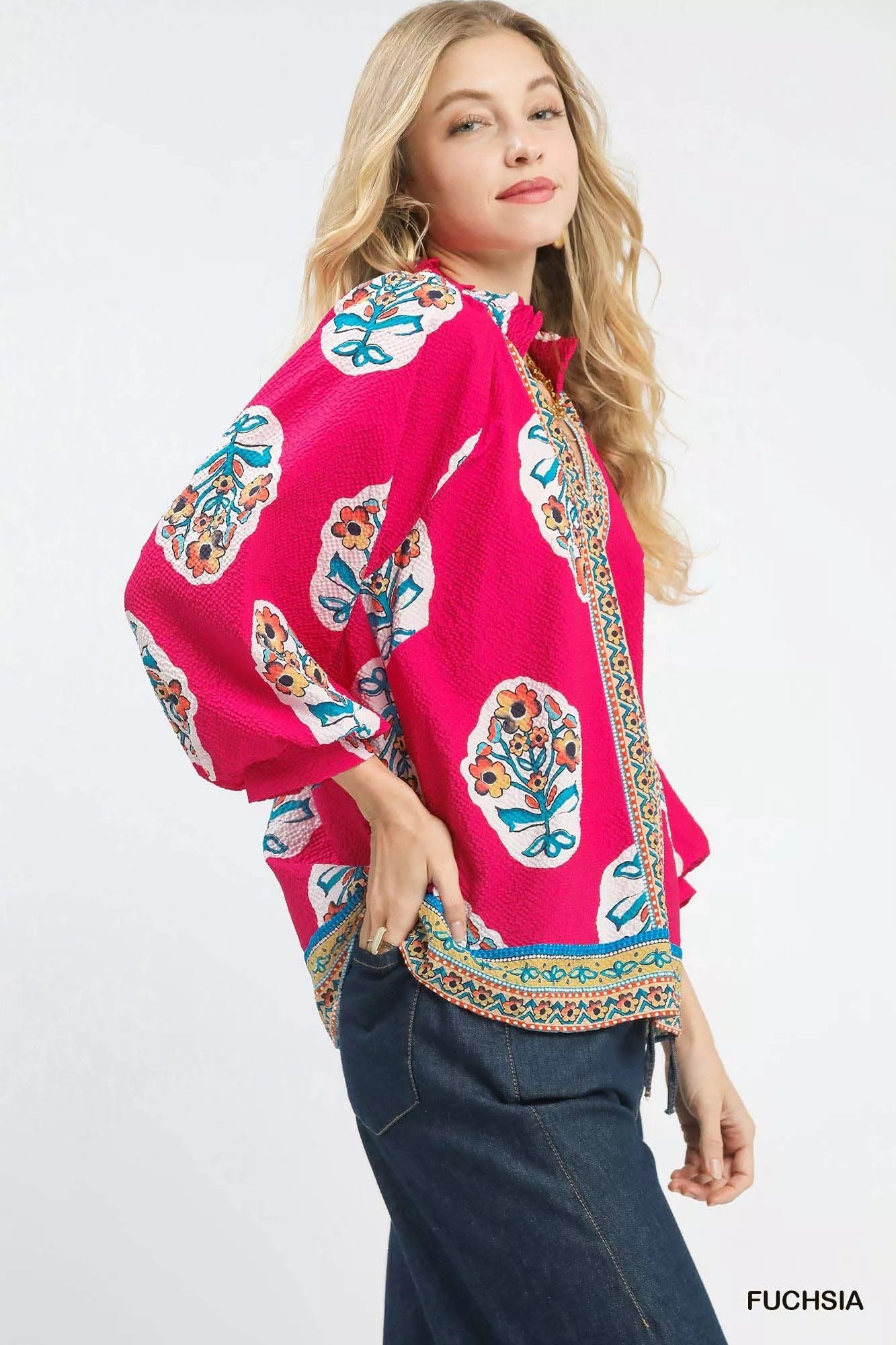 Model wearing Umgee Boho Floral Print Tunic Blouse with flowy sleeves and vibrant floral pattern, side view.