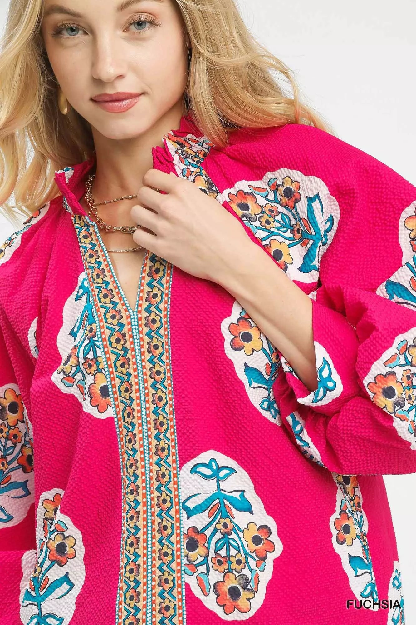 Woman wearing Umgee Boho Floral Print Tunic Blouse with split V-neck and vibrant floral design