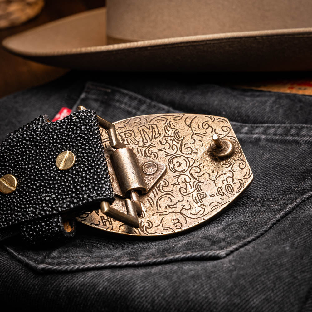 Georgia Belt Black with detailed brass buckle on denim backdrop.