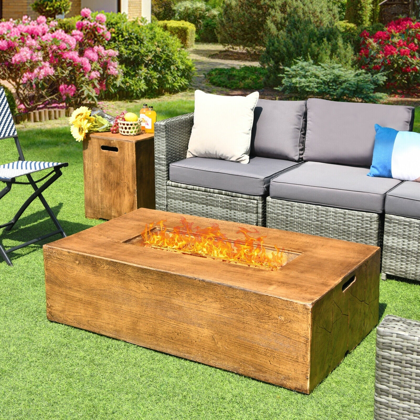 2 Piece Outdoor Propane Fire Pit Table Set in a garden setting with sofa and colorful cushions