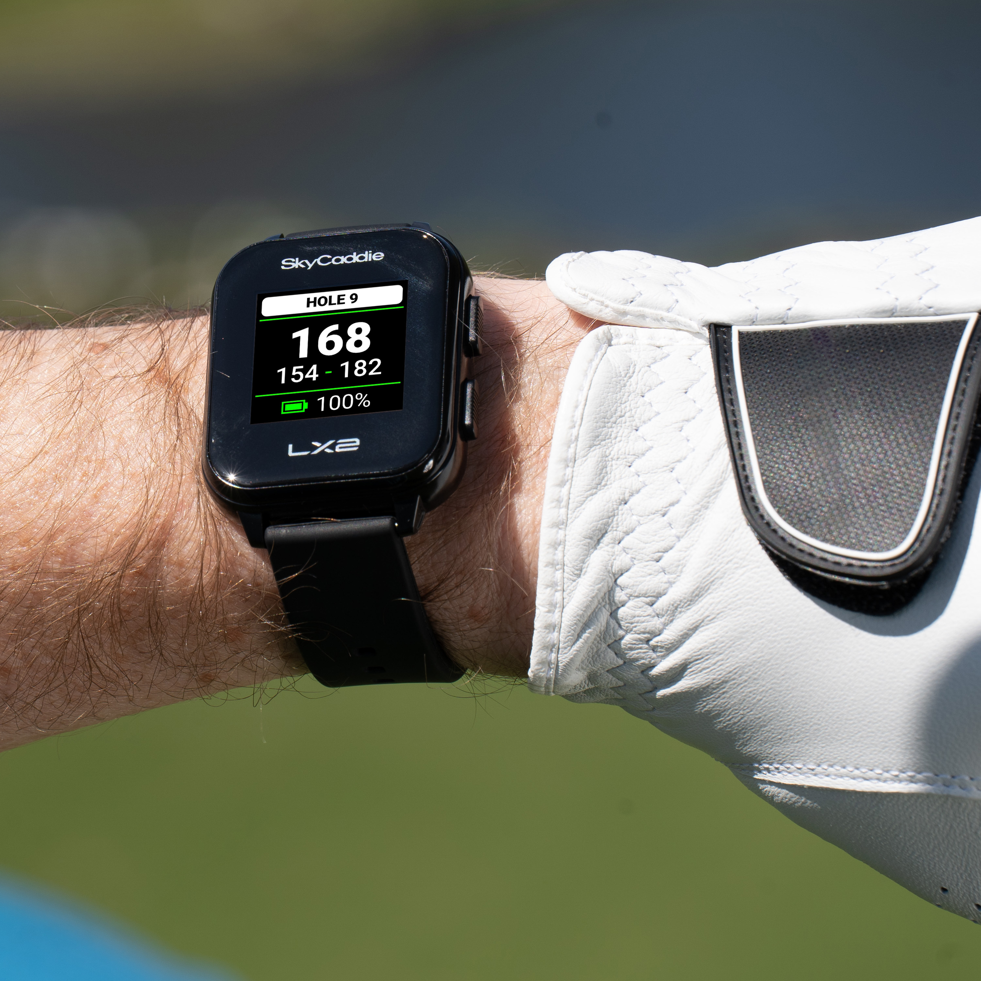 Golfer wearing SkyCaddie® LX2 watch with sunlight-readable display, no annual fees with PAR plan.