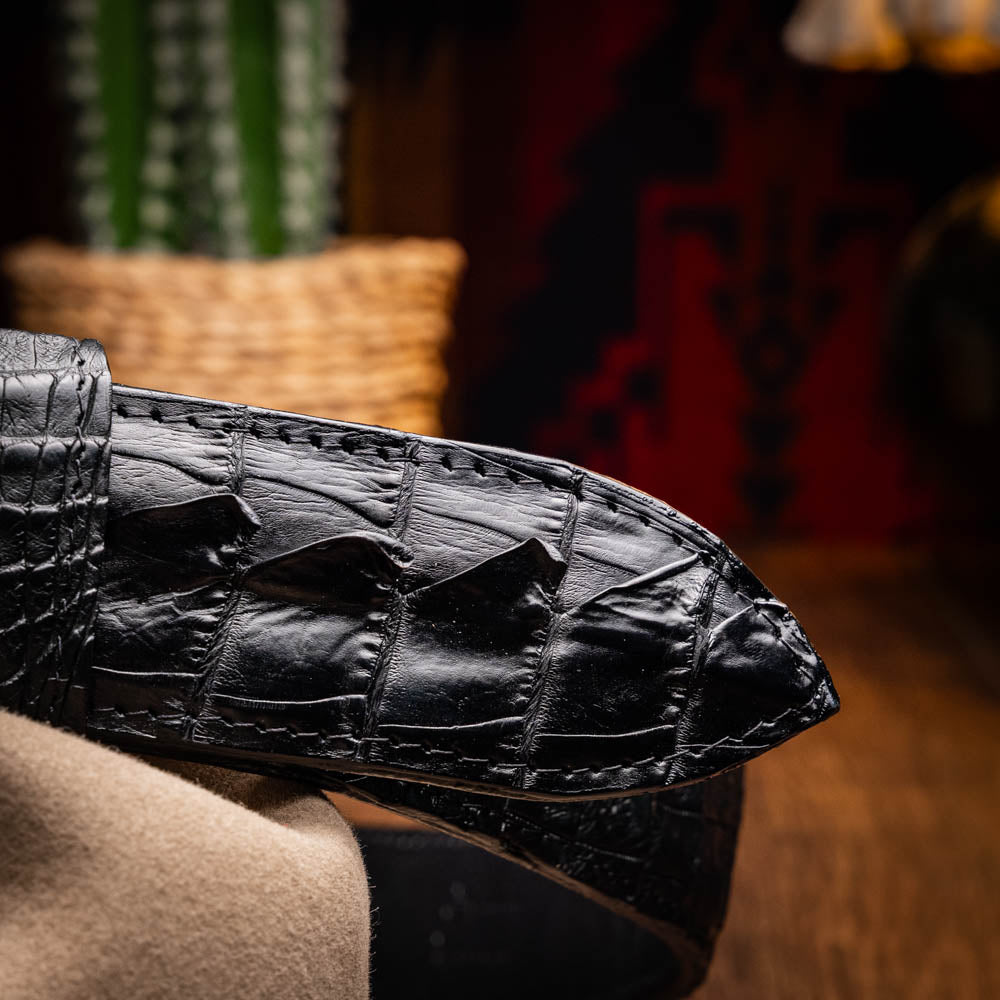 Close-up of Marlboro Belt Black made from hornback caiman skin featuring an antique brass buckle.