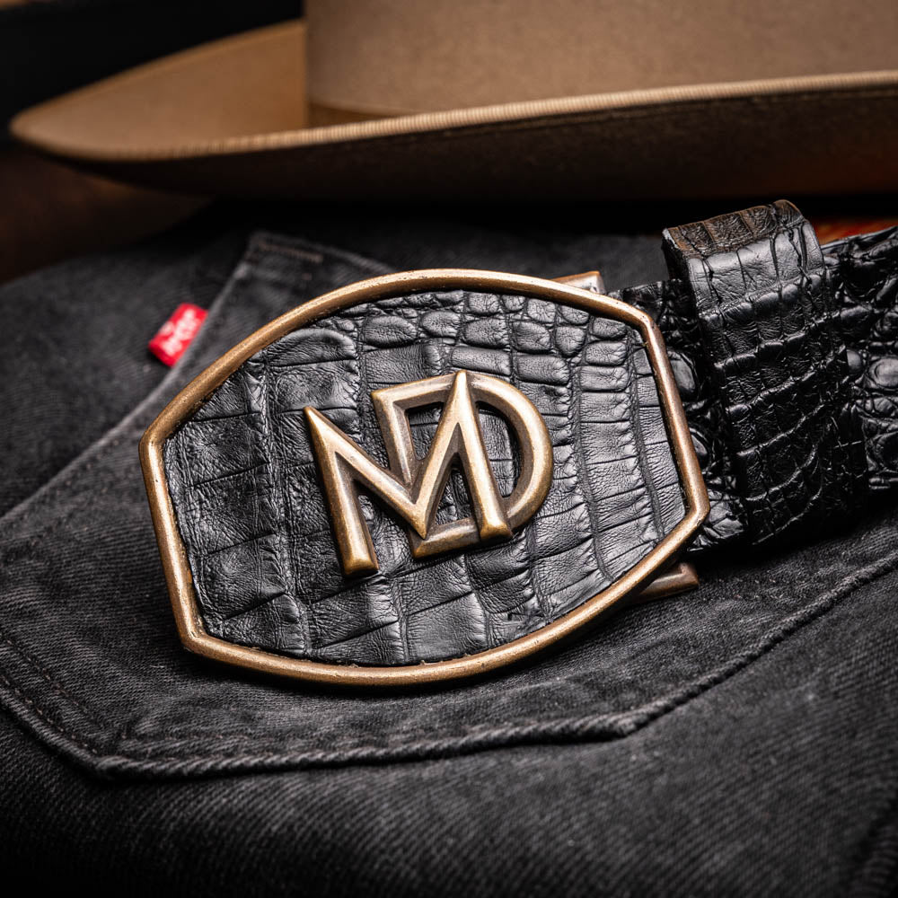 Marlboro Belt Black featuring hornback caiman skin texture with antique brass buckle, displayed on dark denim.