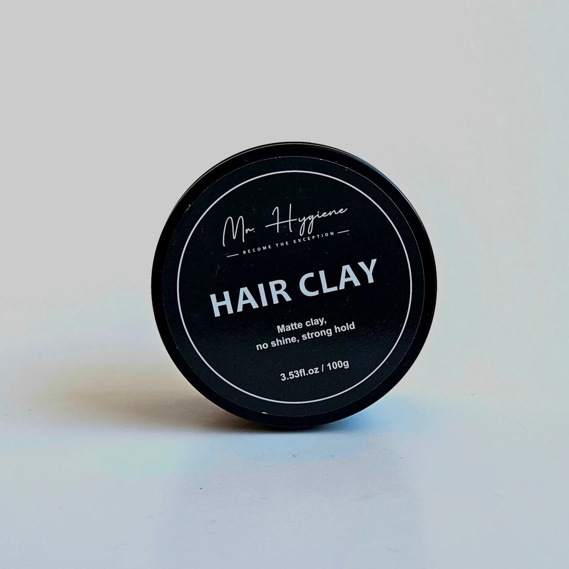 Matte Finish Hair Clay - Strong Hold. Zero Shine. All-Day Control. product image showing clay in black container with strong hold benefits.