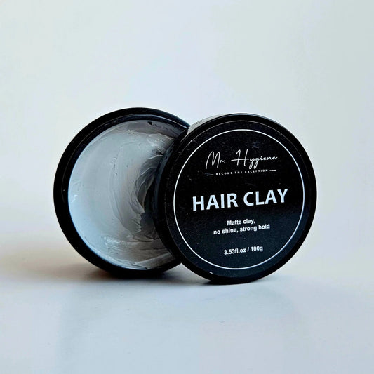Matte Finish Hair Clay - Strong Hold. Zero Shine. All-Day Control. 100g container with open lid displaying clay texture