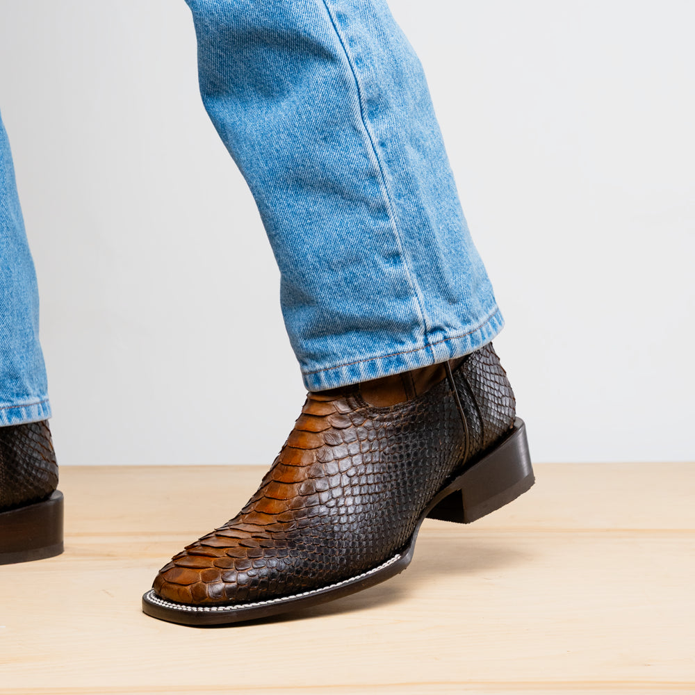 Close-up of Missouri Lisboa genuine Python cowboy boot with square toe and jean cuffs, showcasing Western craftsmanship.