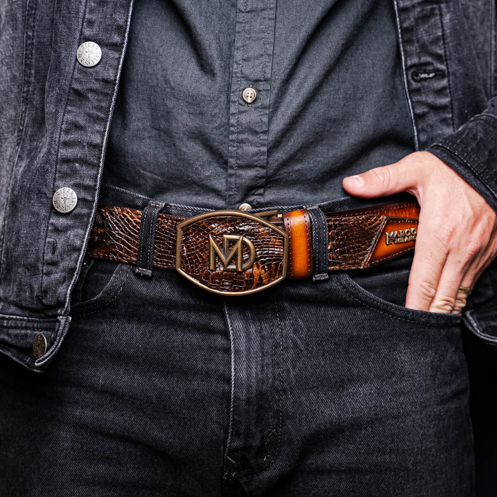 Man wearing Montana Belt Aged Brown with caiman crocodile skin and calfskin leather, featuring Marco Di Milano brand stamp.