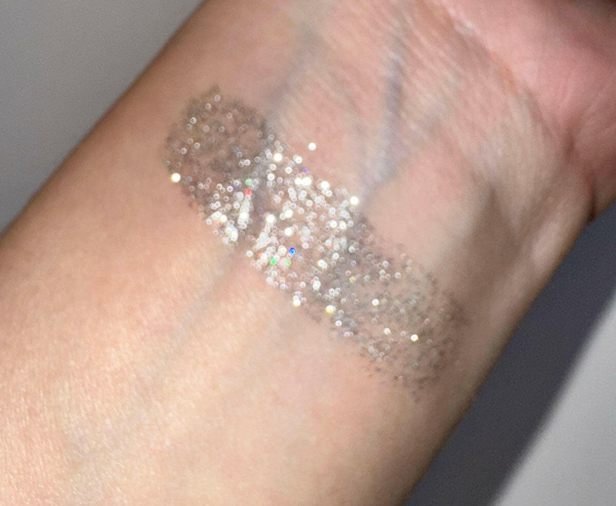 Swatch of Moonlight - Flicker Glitter Eyeliner, a sparkly silver shade on wrist, showing its glittery and buildable coverage.