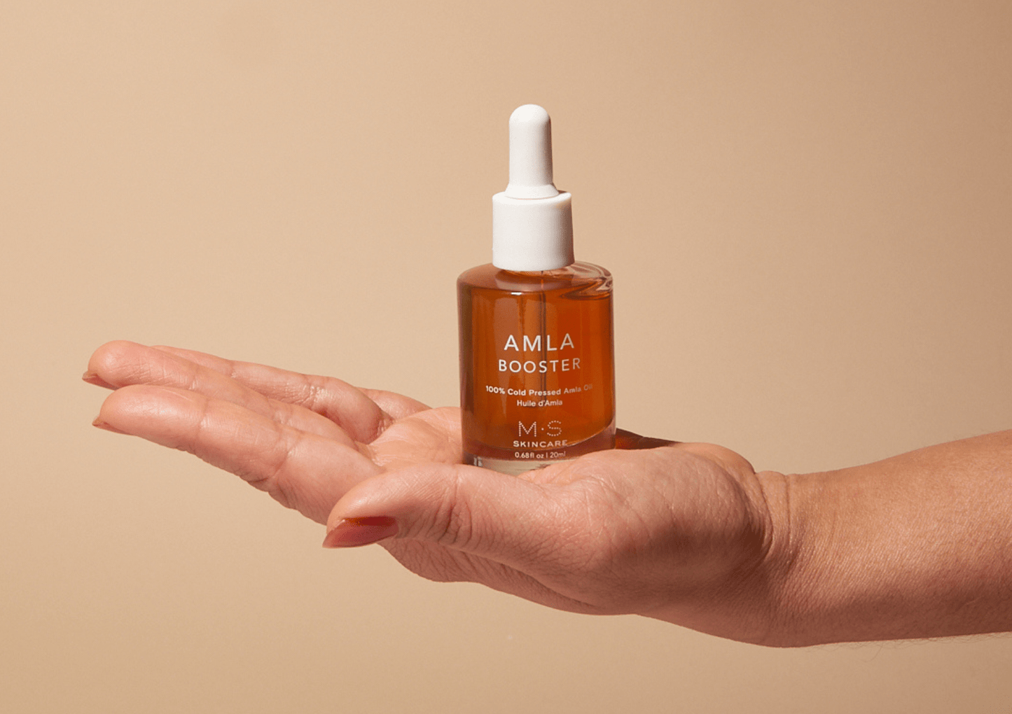 AMLA OIL bottle in hand, antioxidant-rich booster for skin and hair care, improves skin quality and boosts collagen, Ayurvedic benefits