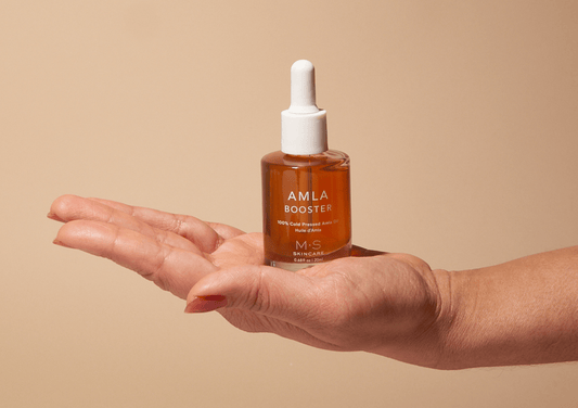 AMLA OIL bottle in hand, antioxidant-rich booster for skin and hair care, improves skin quality and boosts collagen, Ayurvedic benefits