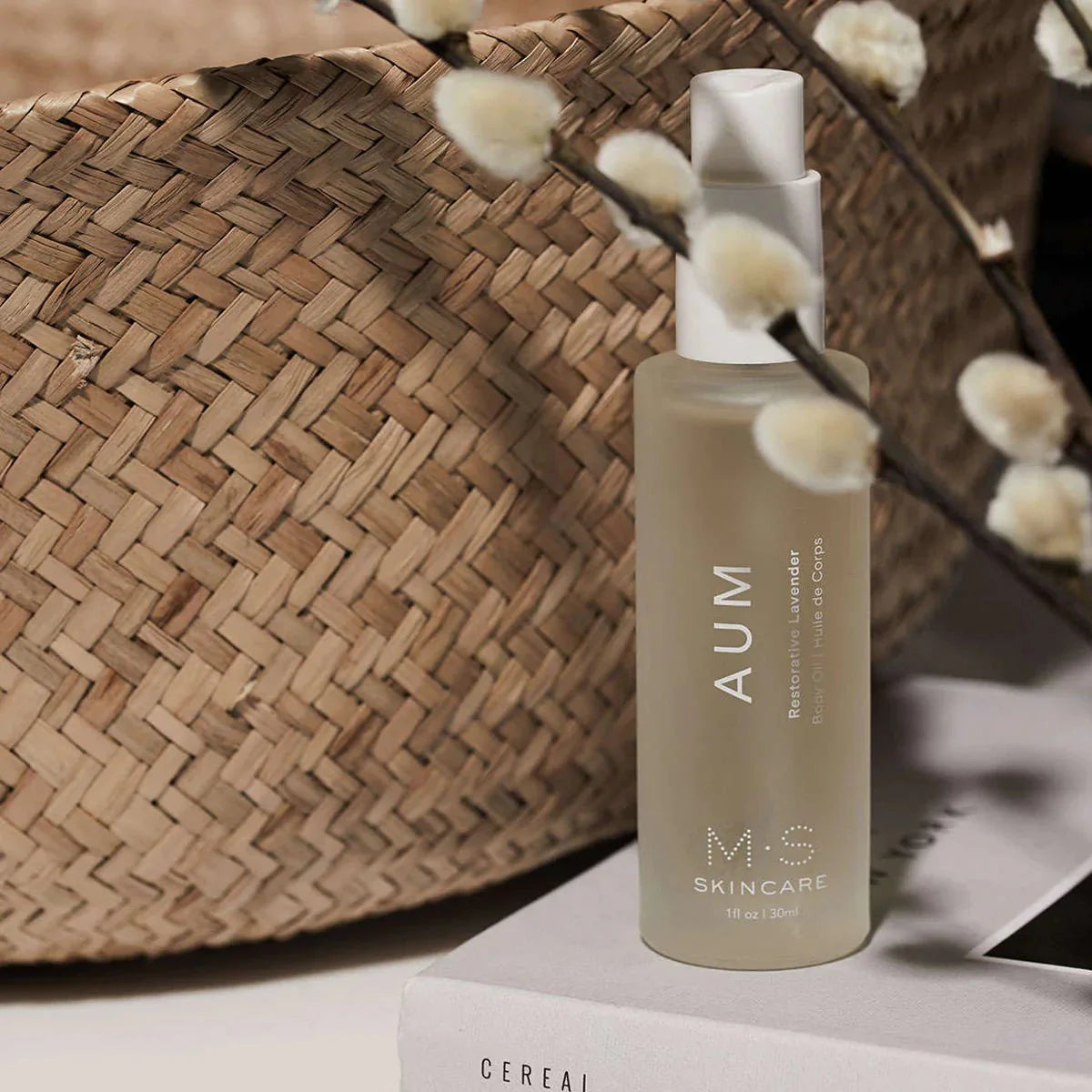 AUM Ayurvedic Lavender body oil bottle with natural basket and floral decor