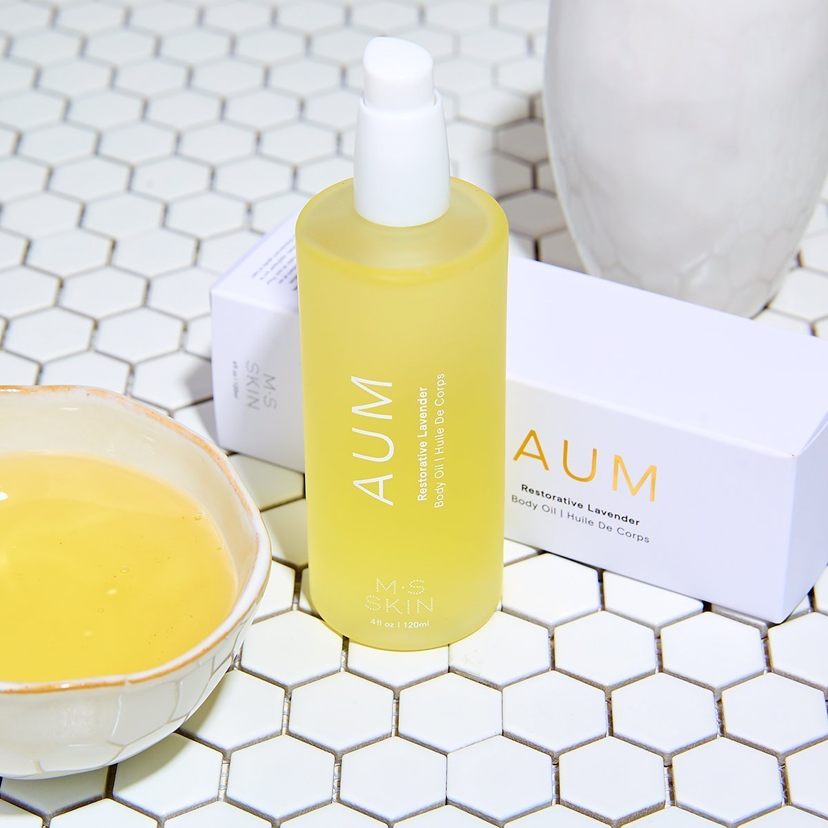 AUM Ayurvedic Lavender body oil with coconut and gotu kola on hex tile background, enhanced with kakadu plum and amla oil.