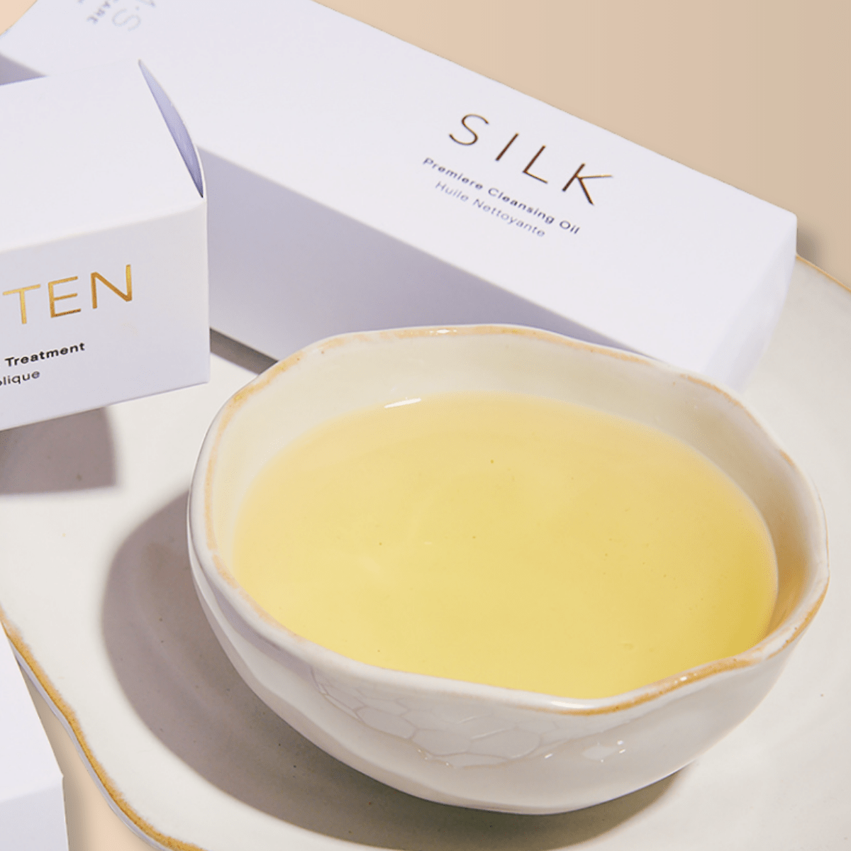 SILK Ayurvedic cleansing oil with nutritive oils in a ceramic dish, featured in luxury skincare packaging on a white tray.
