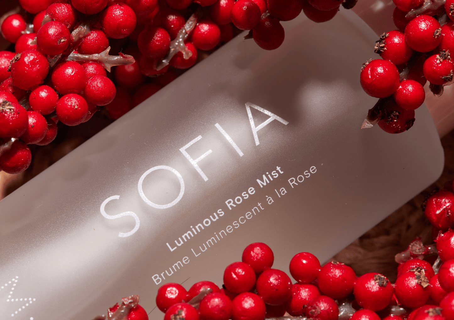 SOFIA rose mist bottle surrounded by red berries in the rose valley