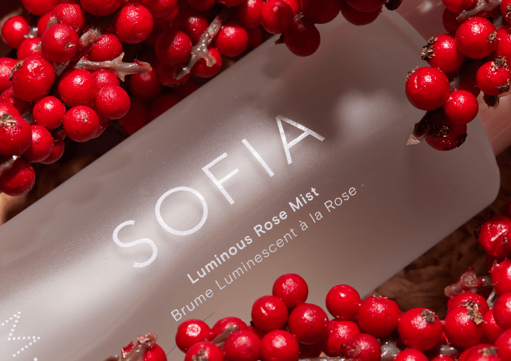SOFIA rose mist bottle surrounded by red berries in the rose valley