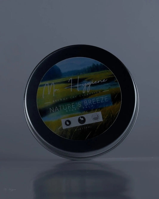 Tin of Nature's Breeze Organic Beard Balm with scenic landscape label, known for hydration and grooming benefits.