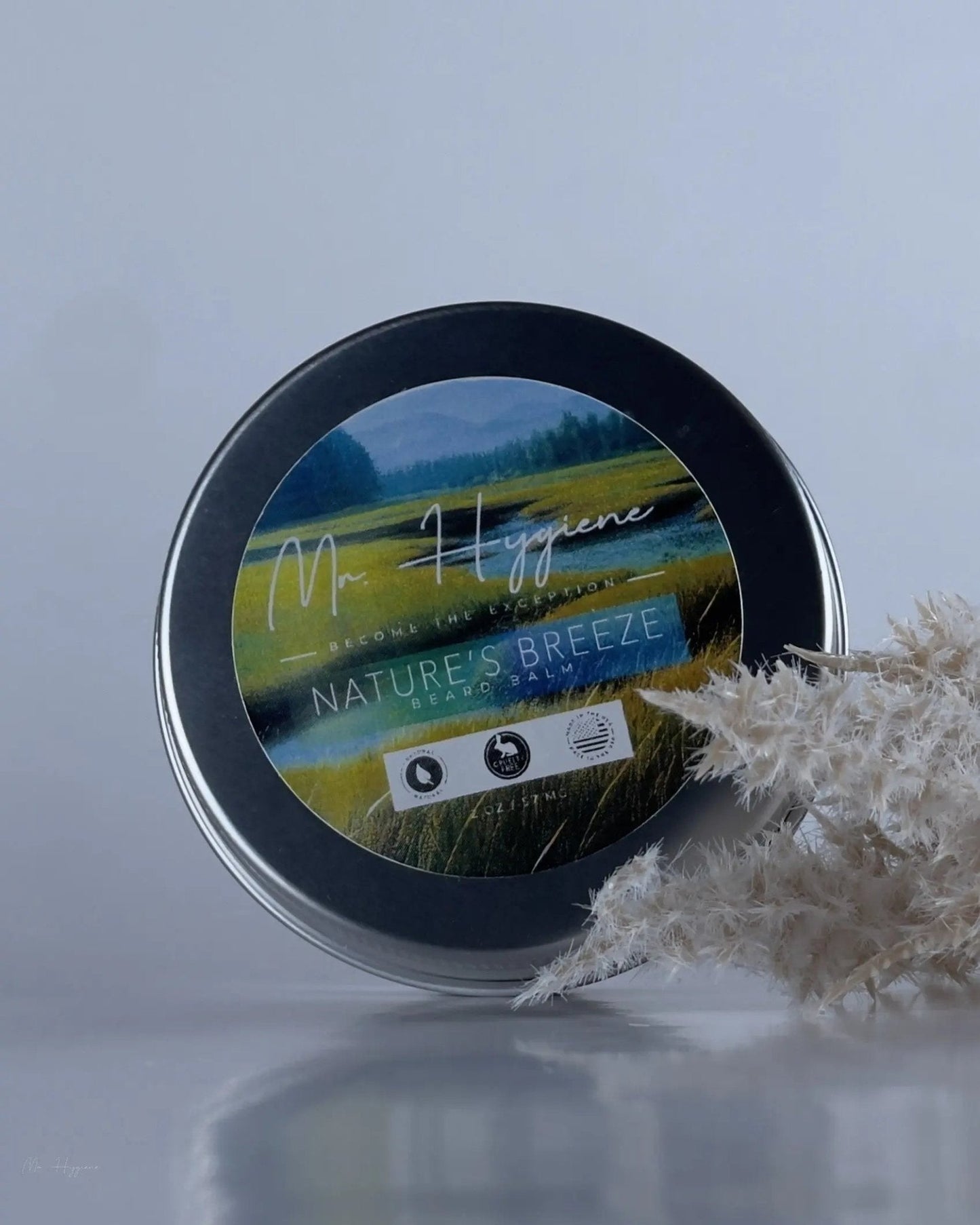 Nature's Breeze Organic Beard Balm tin with nature-inspired label and decorative plants.